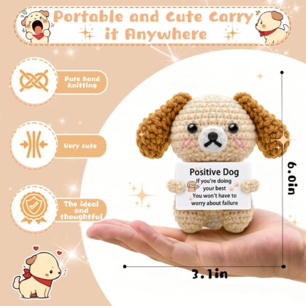 A grey crochet dog miniature figure with floppy ears and blush details, holding a sign with an encouraging message.