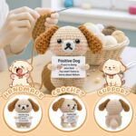 A grey crochet dog miniature figure with floppy ears and blush details, holding a sign with an encouraging message.