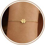 Close-up of a gold-plated DONYUDE dog paw initial charm bracelet on a white background, suitable for women.