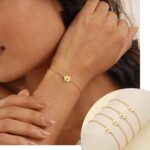 Close-up of a gold-plated DONYUDE dog paw initial charm bracelet on a white background, suitable for women.