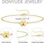 Close-up of a gold-plated DONYUDE dog paw initial charm bracelet on a white background, suitable for women.