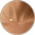 Close-up of a DONYUDE gold-plated necklace featuring a dainty cat's head pendant with the initial 'S' on a polished chain.