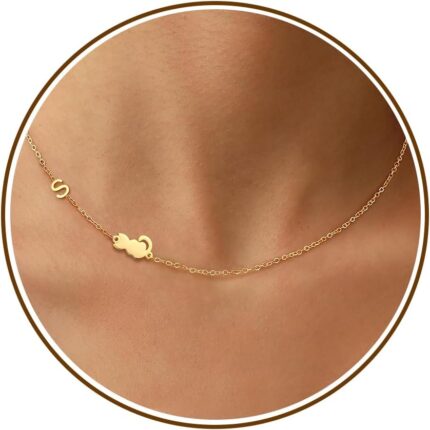 Close-up of a DONYUDE gold-plated necklace featuring a dainty cat's head pendant with the initial 'S' on a polished chain.