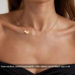 Close-up of a DONYUDE gold-plated necklace featuring a dainty cat's head pendant with the initial 'S' on a polished chain.