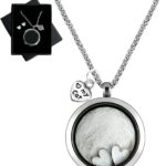 Silvery circular glass and metal necklace with a cat charm, designed to hold pet ashes or fur as a memorial.