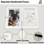A white rectangular wooden frame with a pet's paw print impression in clay, a photo slot, and decorative trinkets.