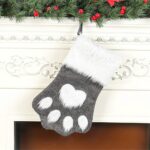 A single grey pet paw shaped Christmas stocking from Sexybody, hanging, with a white cuff and a loop for hanging.