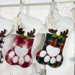A single grey pet paw shaped Christmas stocking from Sexybody, hanging, with a white cuff and a loop for hanging.